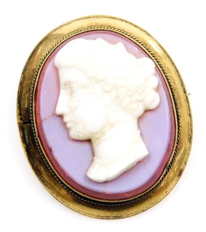 A late 19thC chalcedony and mounted cameo brooch, bust portrait of a lady, in an oval yellow metal frame, with safety chain and pin as fitted.