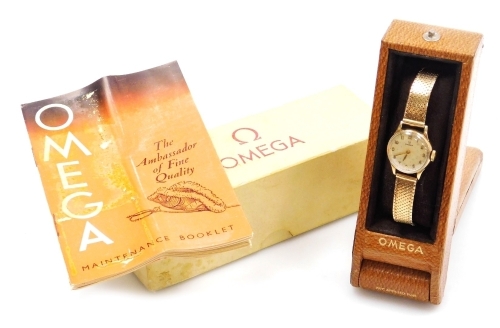 An Omega lady's 9ct gold cased wristwatch, circular champagne dial bearing Arabic numerals, back plate monogram engraved and dated 1953 on a 9ct gold mesh strap, cased and outer boxed, 21.2g all in.