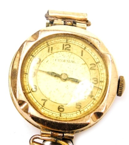 An early 20thC Federal lady's 9ct gold cased wristwatch, circular yellow dial bearing Arabic numerals, on a plated elasticated strap.