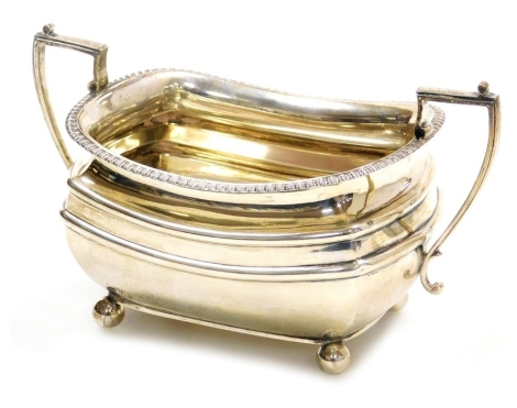 A George V silver two handled sugar bowl, with an embossed repeat line decorated rim, angular handles and raised banding to body, on four ball feet, James Dixon and Sons Ltd., Sheffield 1925, 9.84oz, 10cm high.