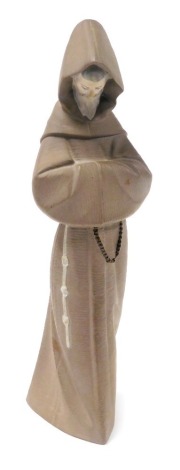 A Lladro matt brown porcelain figure of a monk, modelled in standing pose, printed mark, 33.5cm high.