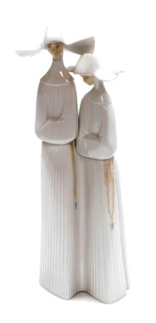A Lladro porcelain figure group of two nuns, number 4611, 33cm high.