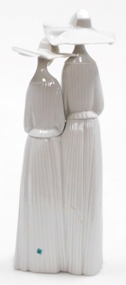 A Lladro porcelain figure group of two nuns, number 4611, 33cm high. - 2