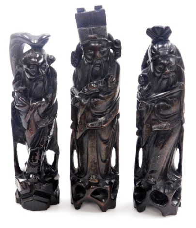 Three Chinese carved hardwood figures of the Sanxing deities, with silver wirework inlay, comprising Shou God of Longevity, 29cm high, Lu God of Prosperity, 33cm high, and Fu God of Fortune, 30cm high.