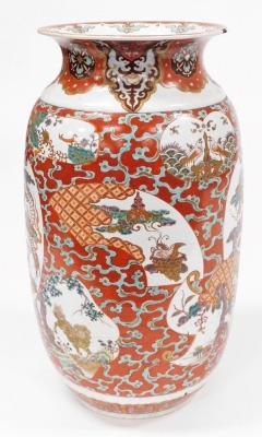 A Japanese Meiji period pottery vase, of cylindrical form with a flared rim, decorated with a reserve to front and verso of a three clawed dragon in clouds, further reserves of birds, trees, etc., on a red ground, 59cm high. (AF) - 4