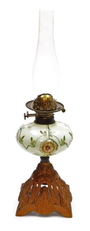 A late 19th Duplex oil lamp, with an opaque floral decorated central reservoir, on a pierced floral decorated cast iron base, lacking shade, 57cm high.