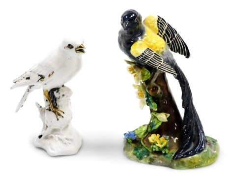 A Crown Staffordshire porcelain figure group modelled as a Yellow-Mantled Whydah bird, on a floral encrusted bough, designed and modelled by J. T. Jones, printed marks, 16cm high, together with a Capodimonte Snow Bunting or Finch, in a white glaze with gi