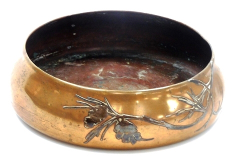 An early 20thC Arts & Crafts Heintz silver on bronze dish, of circular tapering form, with raised decoration of flowering branch, AHMS mark to underside 3589C, 19cm diameter.