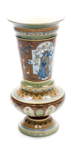 An early 20thC German Mettlach pottery vase, of shouldered form with a tapered neck, raised on a stepped circular footed base, raised and incised decoration, the body decorated with two reserves of maidens holding flowers, with repeat banded floral and le