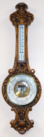 A Victorian oak cased Walker of Newmarket aneroid wall barometer, with a circular enamel dial and mercury Fahrenheit and centigrade measures, the case profusely carved with flowers, scrolls and leaves, patent number 16538, 110cm high.