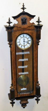 A late 19thC walnut and ebony cased Vienna wall clock, the circular enamel dial bearing Roman numerals with brass chapter ring and subsidiary seconds dial, thirty hour movement, with key and pendulum, 123cm high.