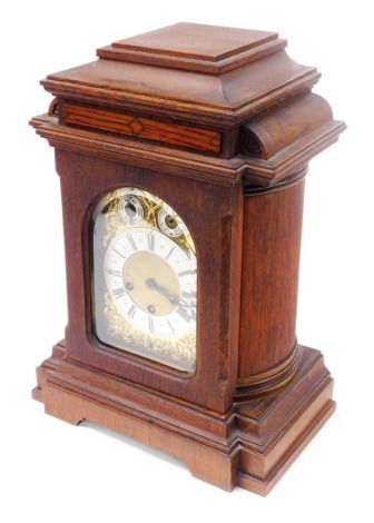 An early 20thC Junghans oak cased mantel clock, rectangular brass dial with foliate spandrels, silvered chapter ring bearing Roman numerals, subsidiary slow/fast and chime/silent dials, eight day movement with coil strike and Westminster chime, the case o