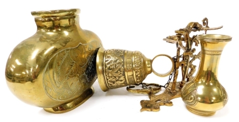 A group of brassware, comprising a vase of oval form, bearing Oriental calligraphy, 20cm high, an Eastern vase of baluster form, with a elongated trumpet stem bearing Arabic lettering, 14.5cm high, and a brass bell, on an ornate decorative support, depict