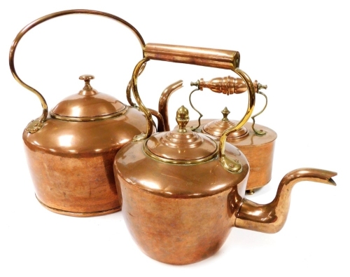 Three Victorian and later copper kettles, the largest 34cm high.