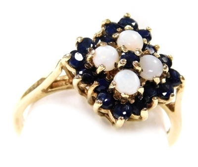 A 9ct gold opal and sapphire ring, with a lozenge shaped floral design, in a high claw basket setting, size O, 3.1g.