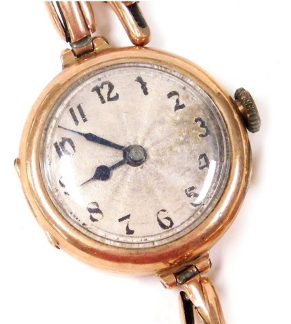 A mid century 9ct gold cased lady's wristwatch, circular silver dial bearing Arabic numerals, Swiss movement, in a circular case, on an elasticated strap, 18.9g all in.