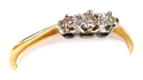 A diamond three stone ring, claw set, in white and yellow metal, size P, 2.0g.