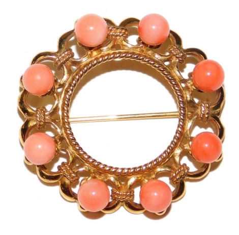 A 9ct gold and coral circular brooch, in an open work design, set with coral beads at intervals, 12.5g.