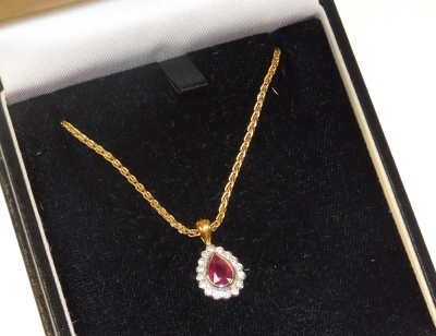 A ruby and diamond pendant, the tear drop shaped ruby in a surround of diamonds, set in white and yellow metal, on an 18ct gold neck chain, with lobster claw clasp, 7.8g.