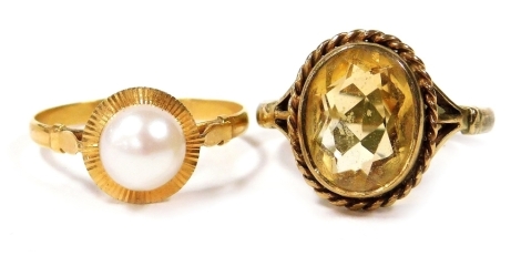 A 9ct gold and citrine ring, oval cut, size P, 3.8g, together with a cultured pearl solitaire ring, in a circular sealed high claw setting, yellow metal, size P, 1.6g. (2)