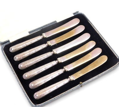 A set of six George V silver handled cake knives, cased, Sheffield 1922, 4.48oz all in.