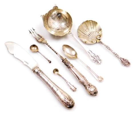 A George VI silver tea strainer, Sheffield 1938, a Continental silver spoon with an embossed shell shaped bowl, stamped sterling, coffee spoon and two salt spoons, 2.4oz, together with a silver handled pickle fork, and a Continental white metal butter kni