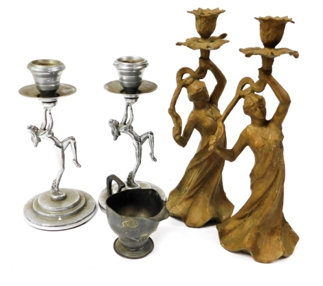 A pair of early 20thC chrome candlesticks, the column moulded as a nude lady, on a stepped base, 21cm high, together with a pewter jug, decorated with flowers, 7cm high, and two further candlesticks.