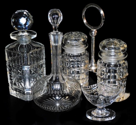 A Victorian cut glass globe and shaft decanter and stopper, further decanter and stopper, an Edwardian boat shaped pedestal salt, and a silver plated holder containing two cut glass jars and stoppers. (4)