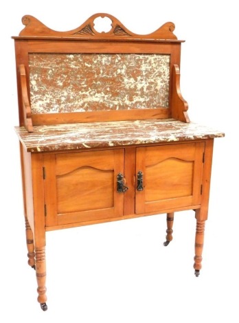 A Victorian satin walnut wash stand, the back with a moulded frieze and inset marble splash back, the base with a marble top above two panelled doors, on turned legs, 132cm high, 92cm wide, 46cm deep.