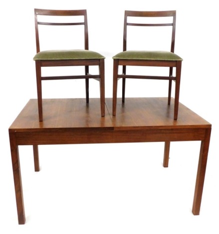 A mid century teak draw leaf dining table, with a rectangular top, raise on square legs, 74cm high, the top 136cm x 81cm, together with two associated bar back chairs, with over stuffed seats. The upholstery in this lot does not comply with the 1988 (Fir