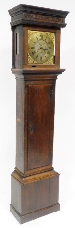 A Georgian oak cased long case clock, by J N Stokes of St Ives, number 667, the brass dial bearing Roman and Arabic numerals, subsidiary seconds dial, with cherub and scroll spandrels, chain driven, the case with scroll carving to the top, on a plinth bas