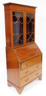 An Edwardian mahogany bureau bookcase, with satinwood cross banding, the outswept pediment with dentil moulding over a pair of astragal glazed doors enclosing two shelves, above a fall flap opening to reveal two drawers and six recesses, over three long g