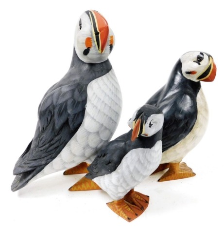 A group of three graduated painted wooden puffins, signed James Haddon, the largest 26cm high.