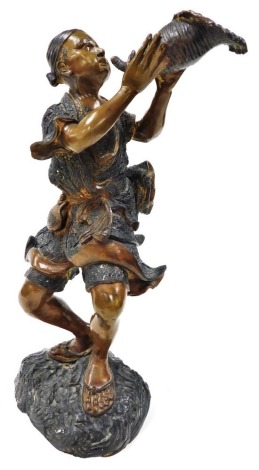 A cast metal bronze patinated figure of a Thai fisherman with conch shell, standing on a rock, 42cm high.