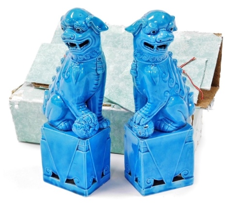 A pair of Chinese turquoise glaze buddhistic dogs of fo, seated on rectangular plinth, 25cm high, with original boxes. Auctioneer announce: 25cm high.