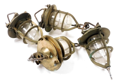 Four brass and glass industrial ceiling lights, two linked as one, each 35cm high.