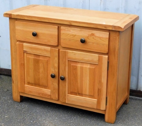 A light oak side cupboard, with a pair of drawers over a pair of cupboard doors, raised on stile supports, 82cm high, 105cm wide, 47cm wide.