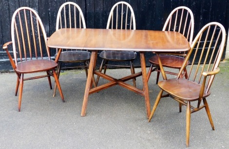 An Ercol dark elm dropleaf dining table, raised on fluted outswept supports, united by an X framed stretcher, 72cm high, 64cm wide, 136cm extended, 73cm deep, together with five Ercol Quaker dining chairs, with loose cushion seats, comprising a pair of ca