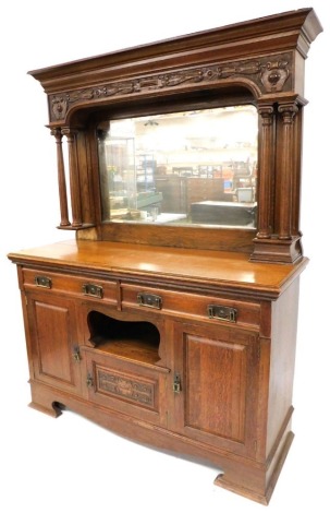 A Victorian walnut mirror back sideboard, the outswept pediment above a carved frieze, raised on two pairs of fluted columns, with a bevelled glass plate back, above two frieze drawers, central recess and small cupboard door flanked by two further panelle