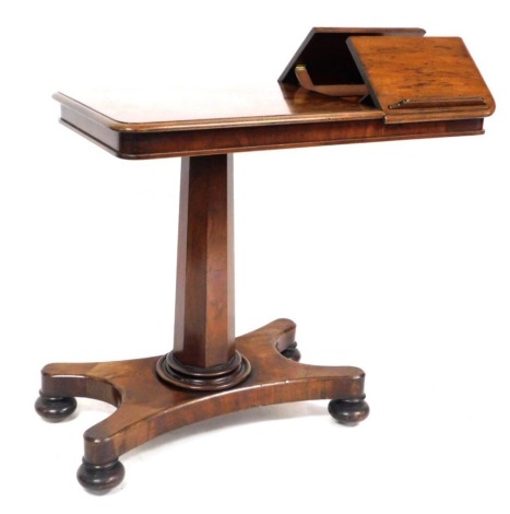 A Regency mahogany reading table, the oval top with two folding book lecterns, raised on a tapering octagonal column and quatrefoil base, on bun feet, 77cm high, 91cm wide, 45cm deep.