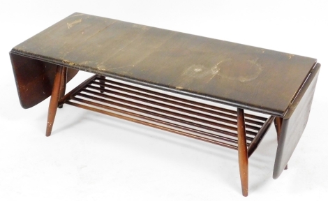 An Ercol dark elm and beech drop leaf coffee table, raised on turned legs united by a slatted under tier, 37cm high, 108cm wide, 159cm extended, 45cm deep. (AF)