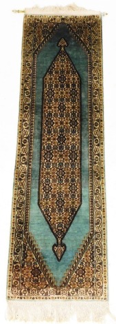 A Turkish turquoise blue silk runner, with a central floral medallion, within repeating floral borders, 135cm x 42cm.