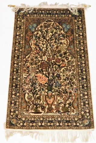 A Kashmiri cream ground silk prayer rug, the mihrab filled with a vase of flowing flowers and perched birds, within repeating floral borders, 127cm x 76cm.