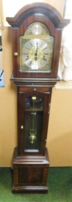 A 20thC Thomas Byrne mahogany cased grandmother clock, the brass break arch dial bearing mask and foliate spandrels, silvered chapter ring bearing Roman and Arabic numerals, eight day movement with Westminster chimes, the case of plain form with a glazed