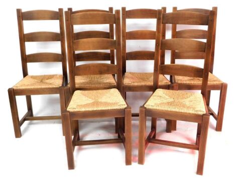 A set of six light oak ladder back dining chairs, with rush seats, raised on square legs united by an H frame stretcher.