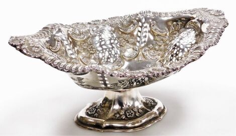 A Victorian silver pedestal dish, of shaped oval form, with floral, scroll and leaf embossing and pierced leaf decoration, maker's marks rubbed, Birmingham 1899, 16.03oz, 9.5cm high, 27.5cm wide.