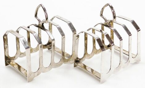 A pair of George V silver four division toast racks, each of plain form with an open shield shaped handle, Viner's Ltd, Sheffield 1932, 7.35oz, 11cm high, 9cm wide.