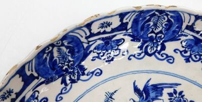 An 18thC Delft blue and white charger, with a waved border, the centre decorated with a vase surrounded by birds and flowers, within a repeating floral border, unmarked, 34.5cm diameter. - 5