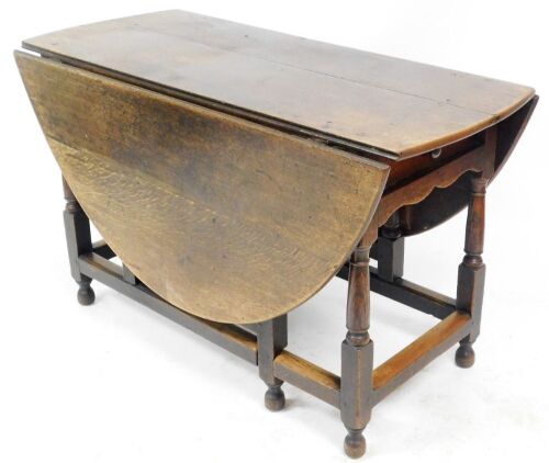 A Georgian oak gate leg table, with frieze drawer to one side, raised on turned legs united by a box stretcher, 73cm high, 120cm wide.