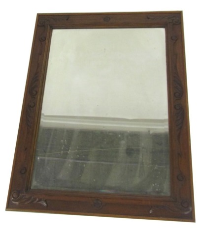 A Victorian oak framed rectangular wall mirror, with a carved floral and scroll border, 108cm x 84cm.